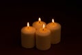 Four whiteÃÂ candlesÃÂ flameÃÂ burningÃÂ onÃÂ dark backgroundÃÂ withÃÂ copyÃÂ space forÃÂ text Royalty Free Stock Photo